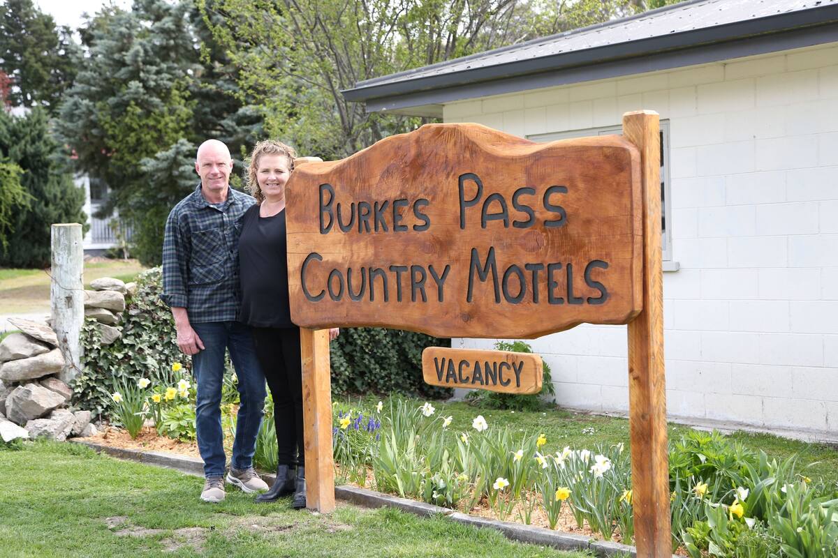 En träskylt för Burke’s Pass Country Motels, med en mindre skylt under som visar att det finns lediga rum.