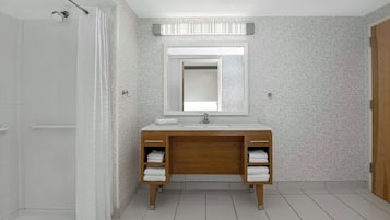 A modern bathroom with a shower, a double sink vanity, and a mirror.