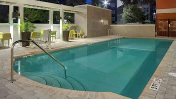 A rectangular swimming pool with a tiled edge, a metal handrail, and a sign indicating a 3ft depth.