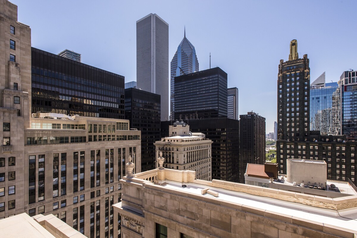 A high-rise building with a modern glass facade, surrounded by other tall buildings.