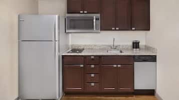 A compact kitchen with a refrigerator, microwave, sink, and dishwasher.