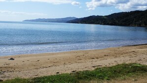 Ein Strand mit sandigem Ufer und ruhigem Wasser.