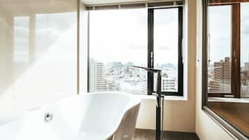 Ein modernes Badezimmer mit einer freistehenden Badewanne, einem großen Fenster mit Blick auf die Stadt und einem eleganten, minimalistischen Design.