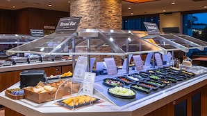 Un espace buffet avec des sections clairement identifiées pour le pain, les plats chauds et les salades.