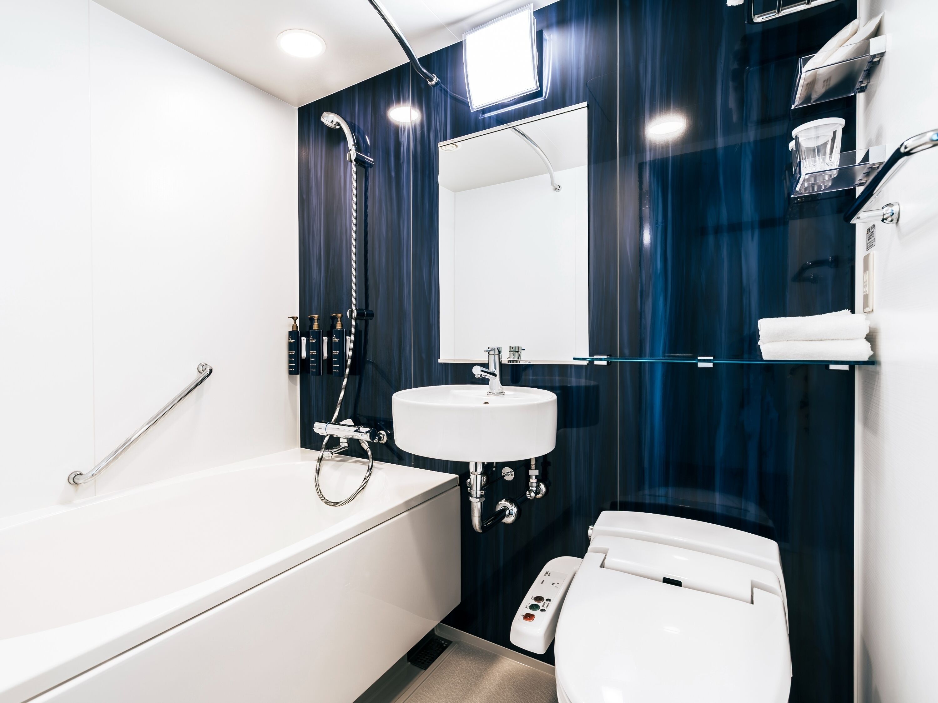A modern bathroom with a white bathtub, a white sink, and a toilet.
