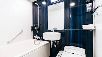A modern bathroom with a white bathtub, a white sink, and a toilet.