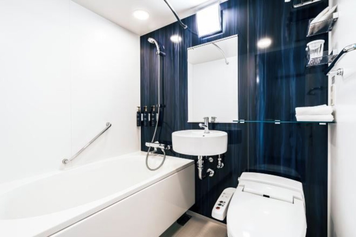 A modern bathroom with a white bathtub, a white sink, and a white toilet.