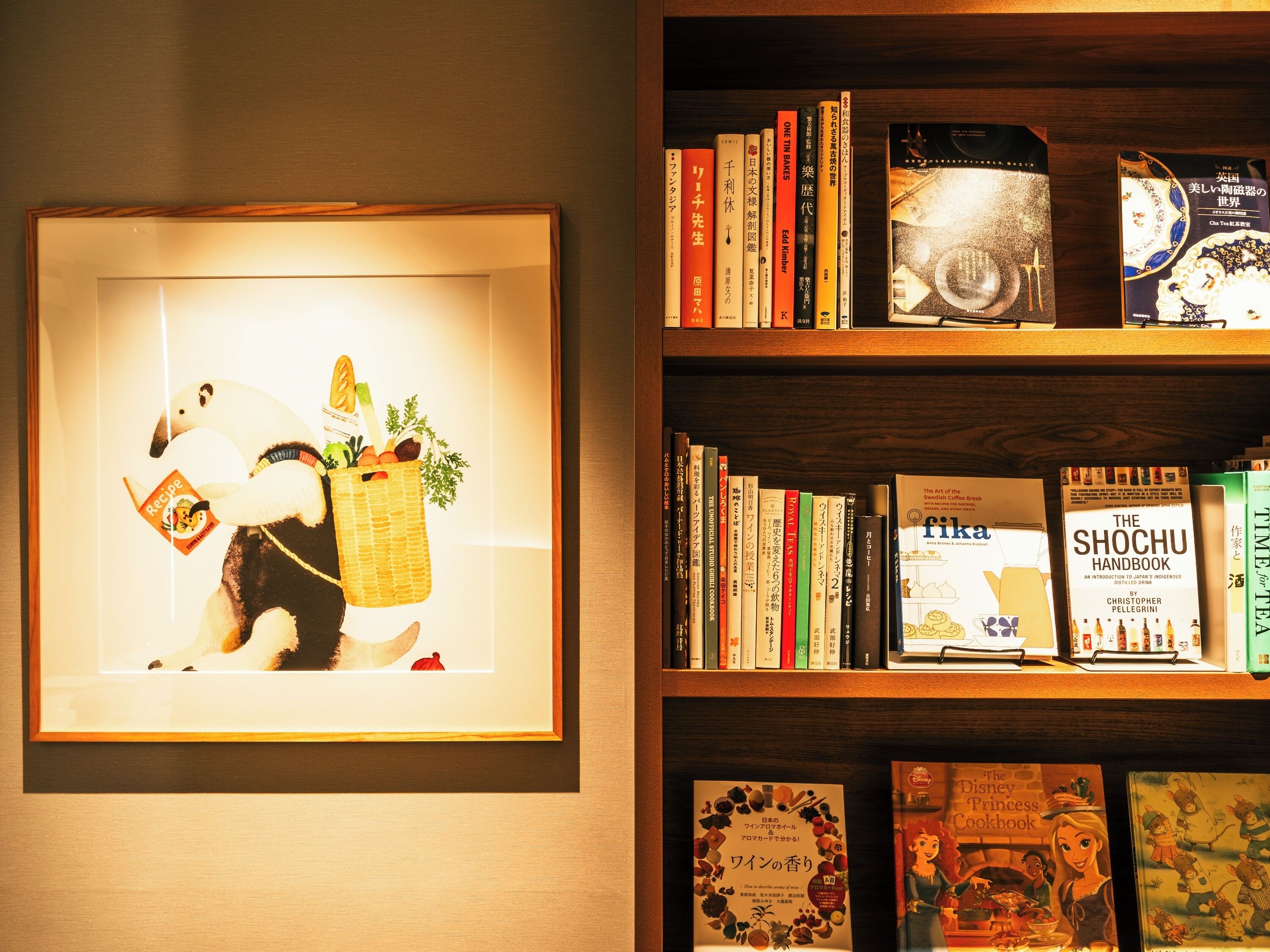 A framed picture of a panda holding a recipe book, surrounded by bookshelves with various books and a DVD.