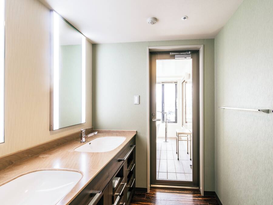 Uma casa de banho moderna com duas pias, um espelho grande e uma porta que dá para uma varanda.