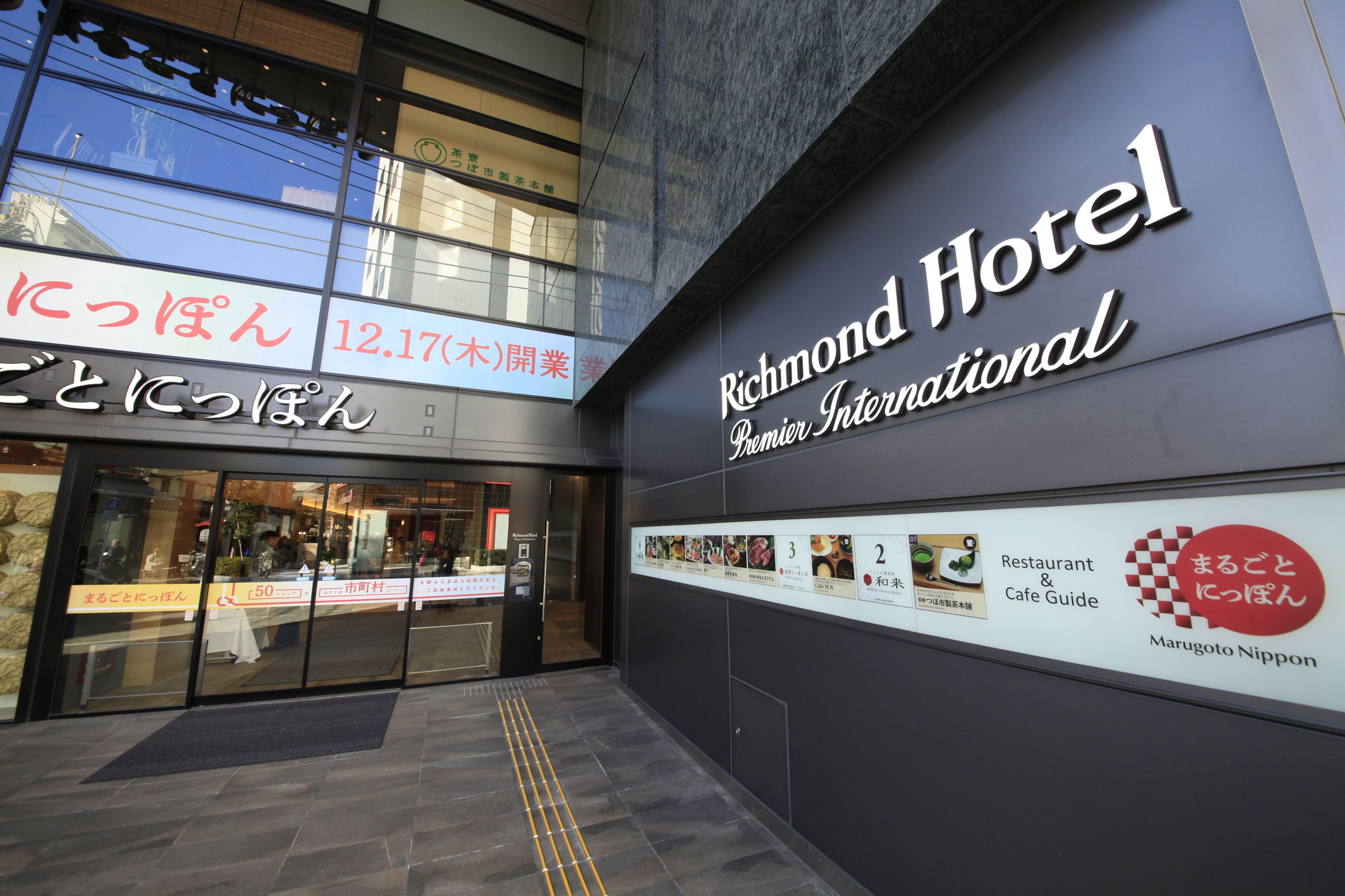 The exterior of Richmond Hotel with a clear entrance, a signboard with the hotel name, and a restaurant guide display.
