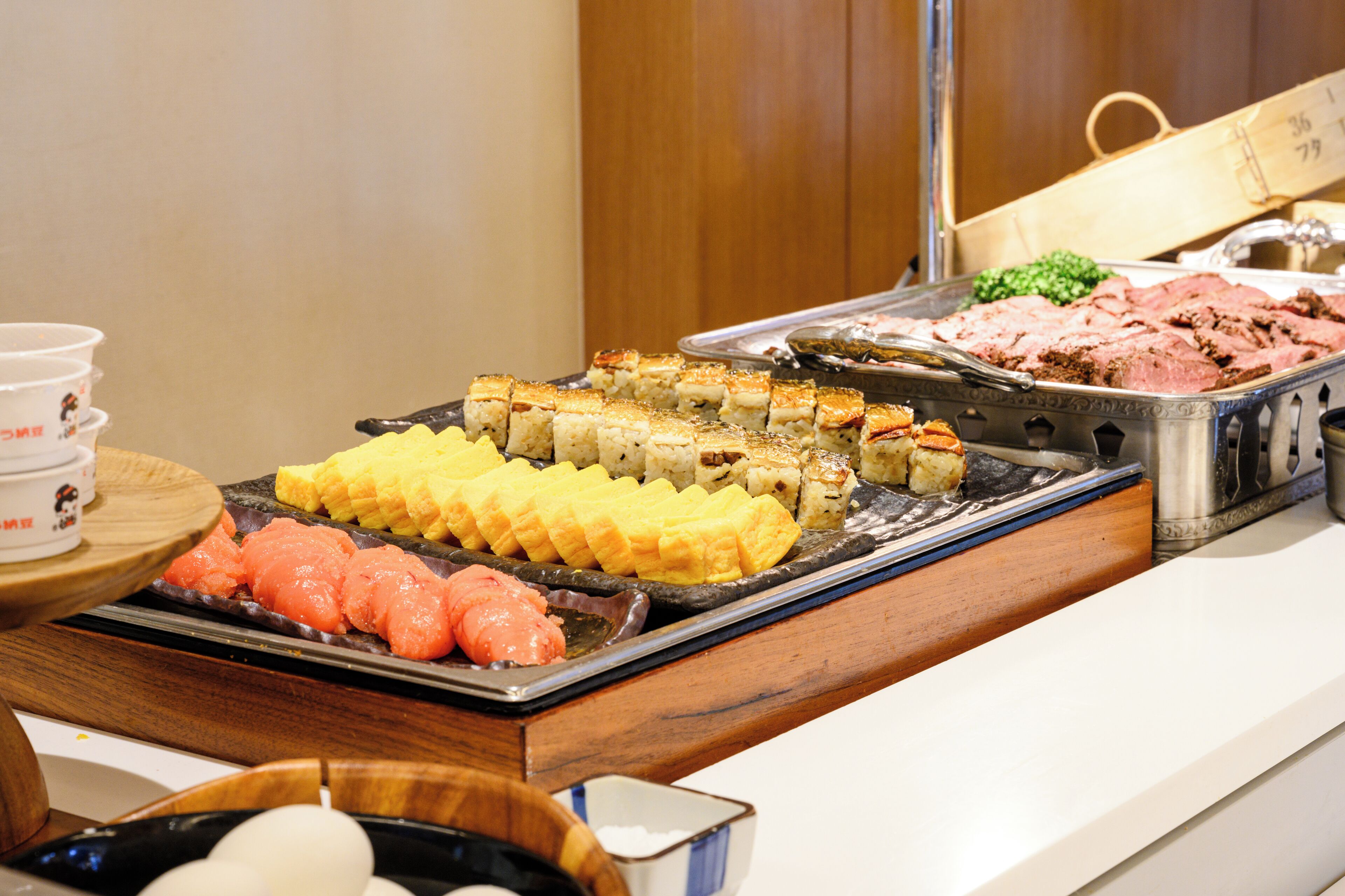 A buffet with various food items including sushi, sashimi, and other dishes.