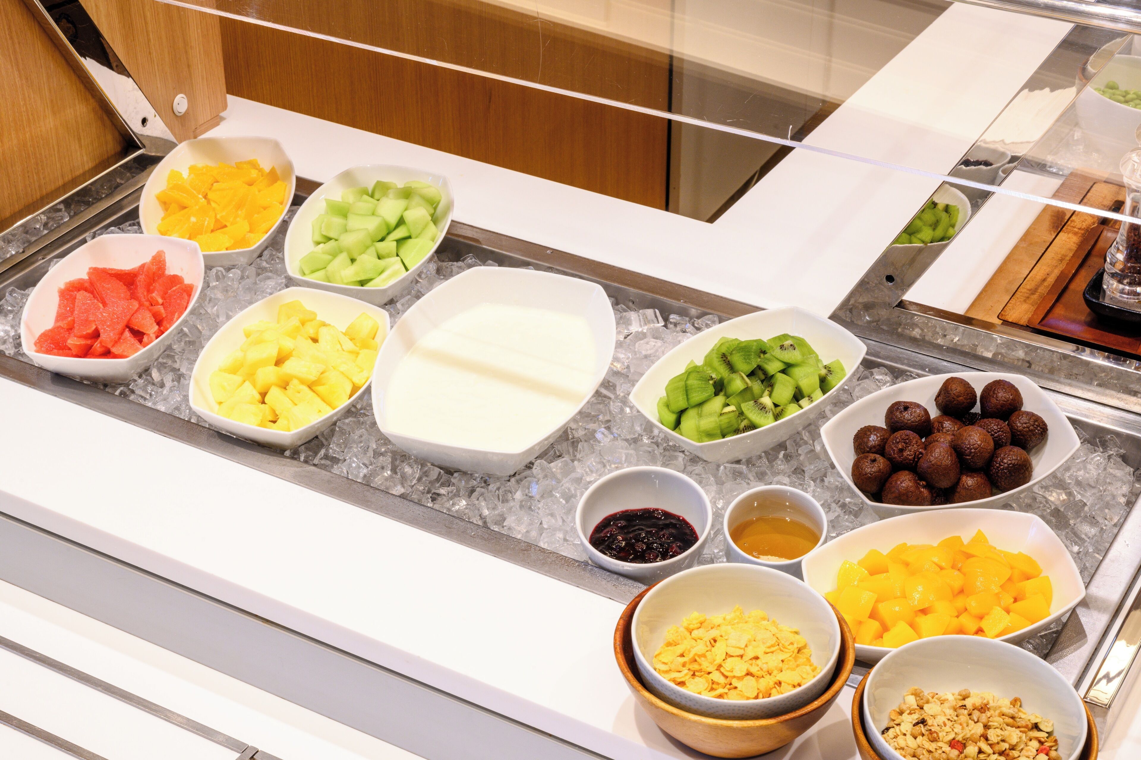 A buffet with various fruits and desserts.