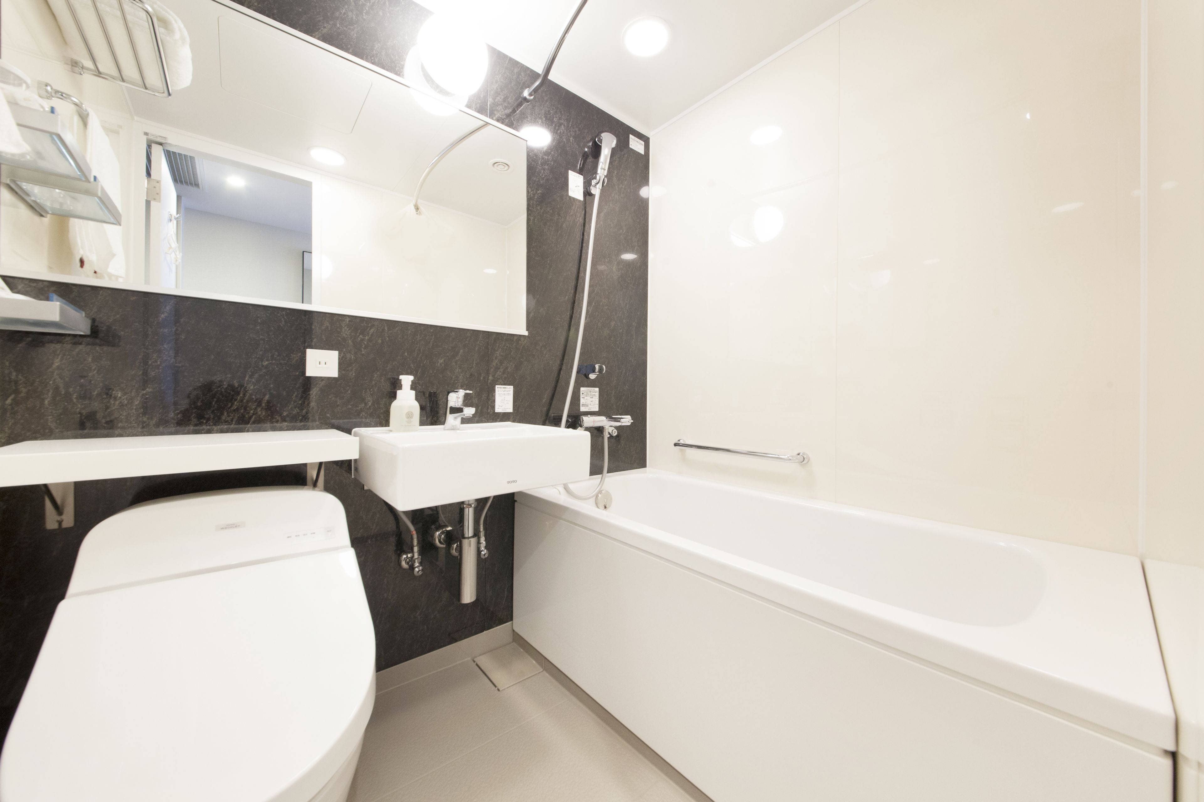 A modern bathroom with a toilet, sink, and bathtub.