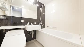 A modern bathroom with a toilet, sink, and bathtub.