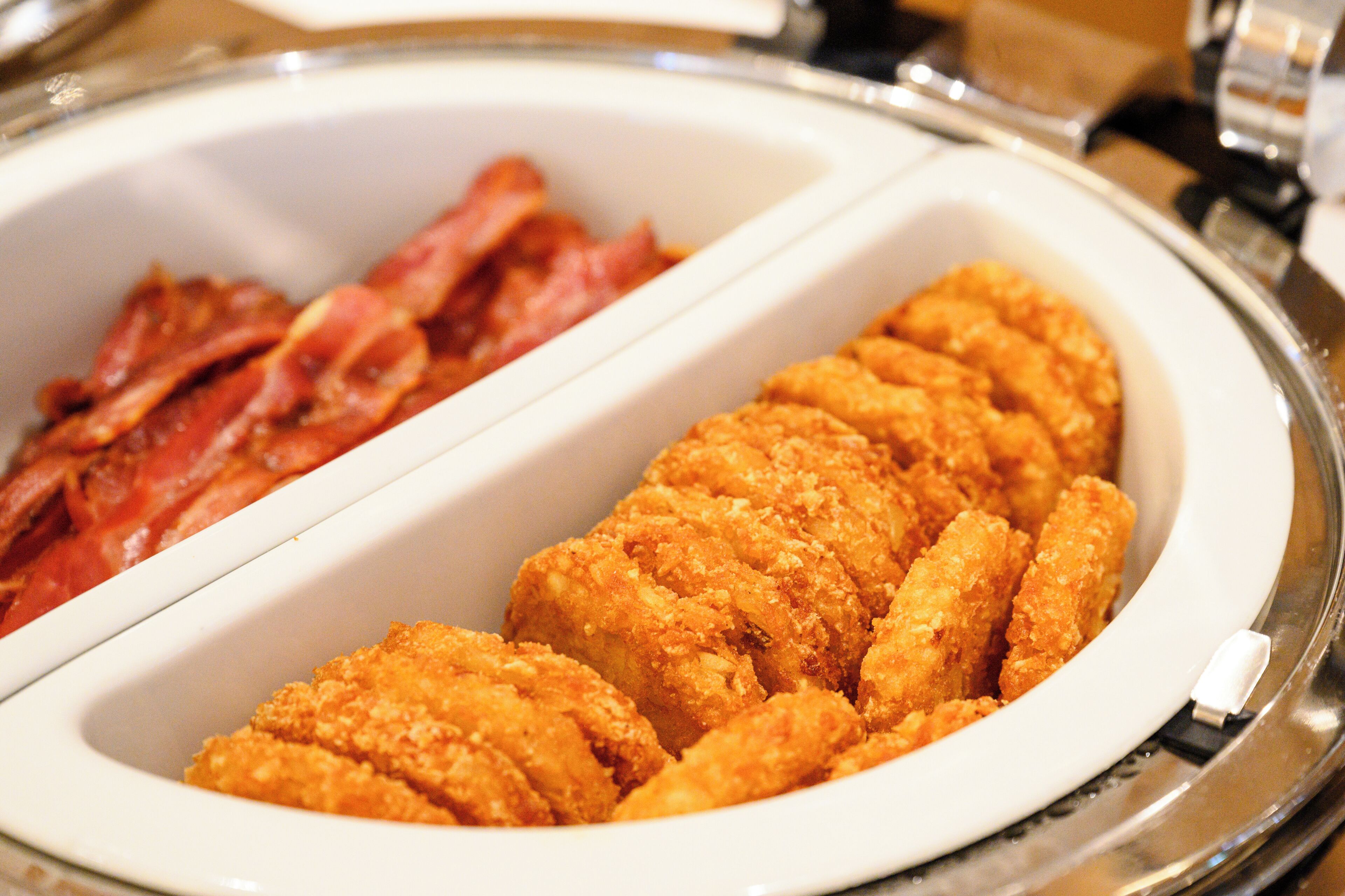 A buffet with fried chicken and bacon.