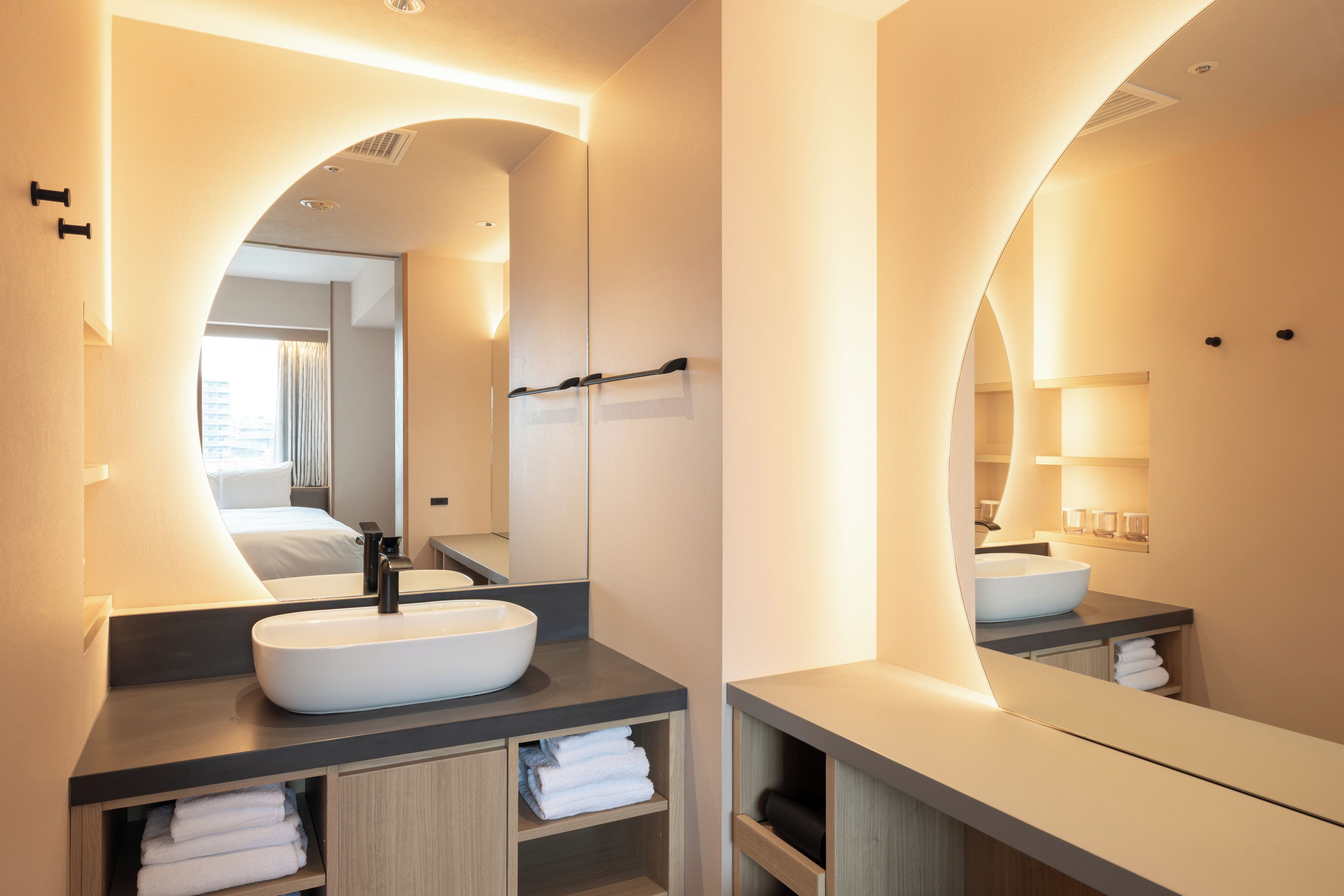 A modern bathroom with a large mirror, a vessel sink, and a towel rack.