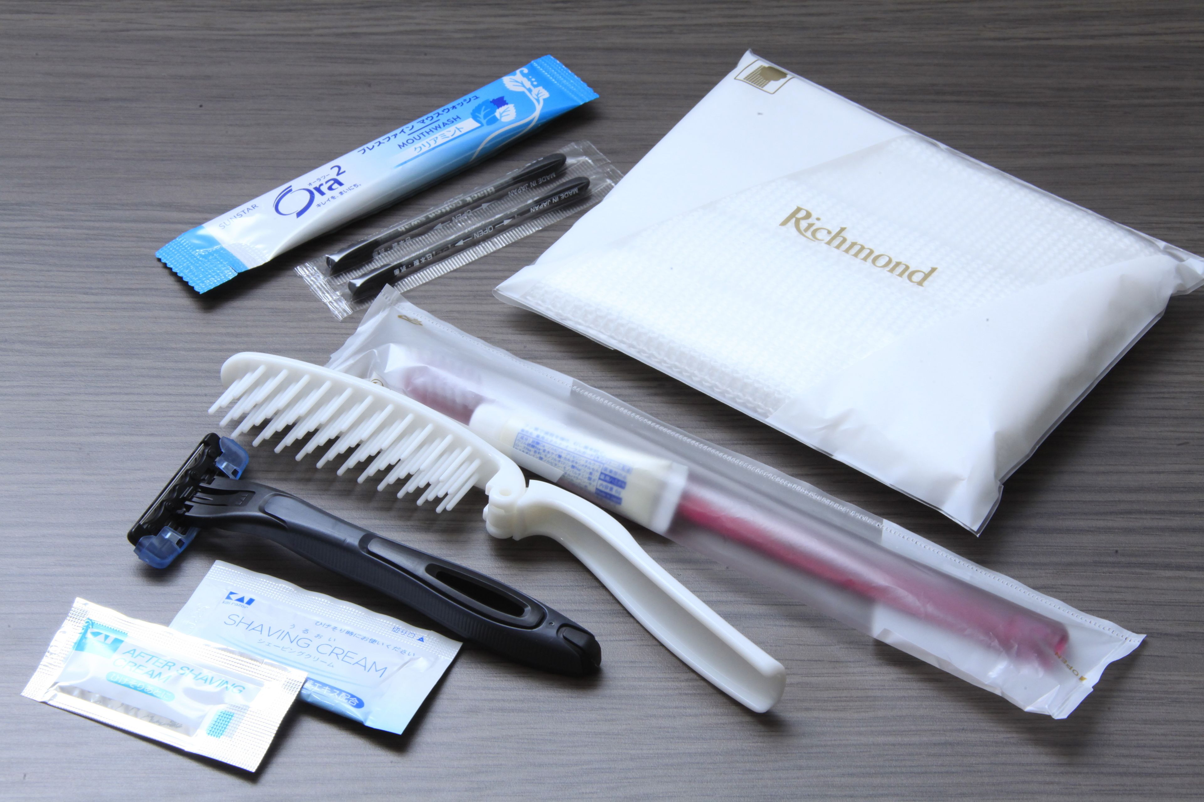 A collection of grooming items including a razor, comb, shaving cream, and a pouch labeled 'Richmond'.