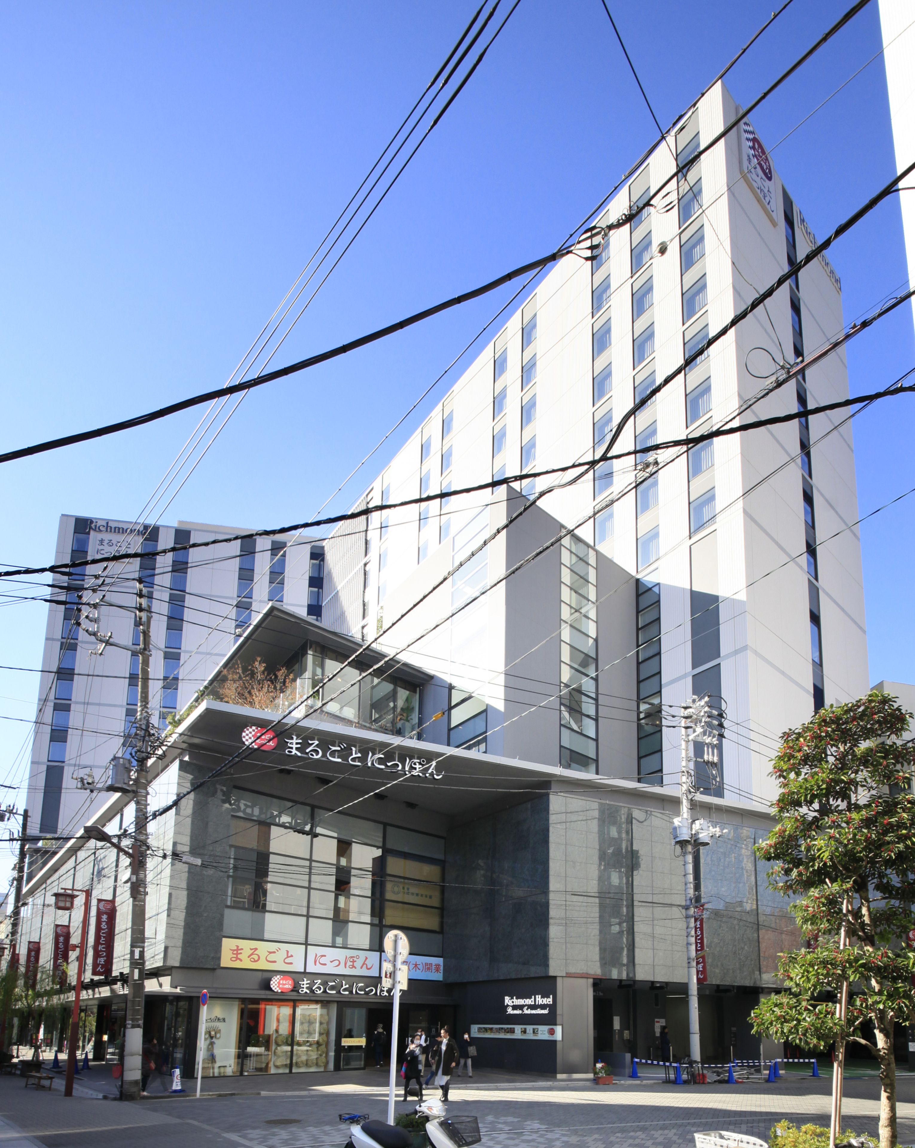 A modern hotel building with multiple floors, large windows, and a prominent sign for Richmond Hotel.