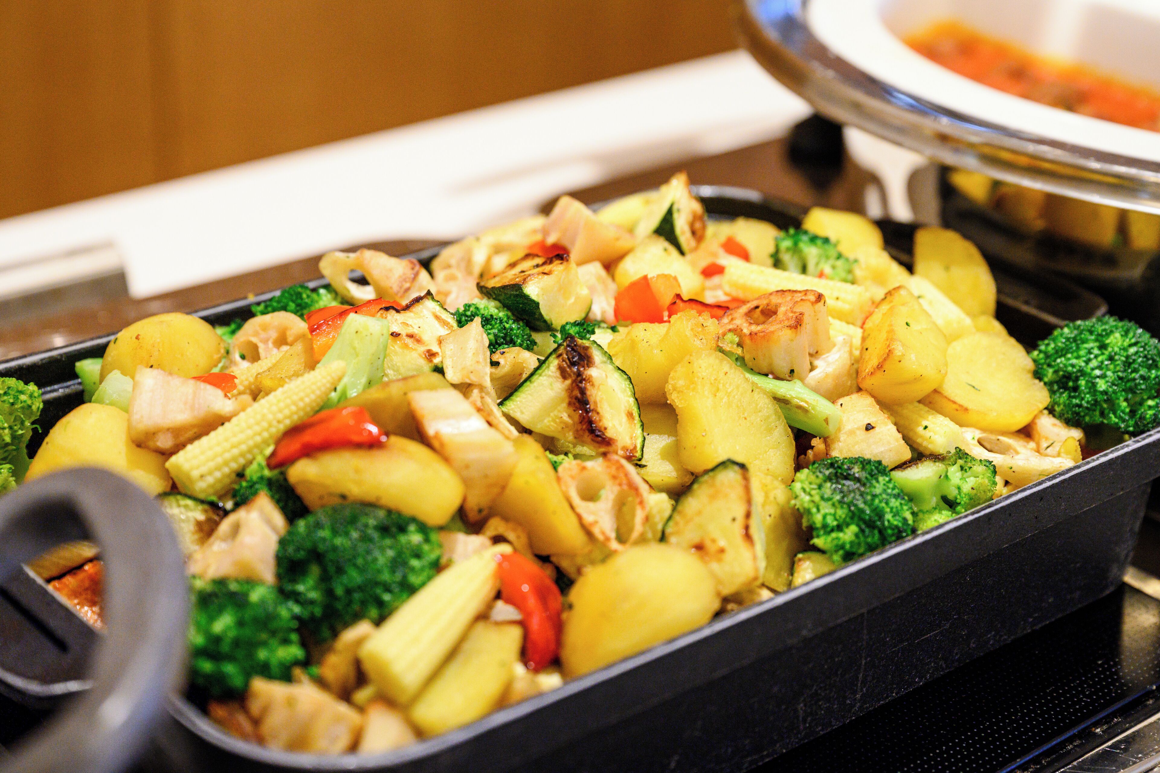 A tray of mixed vegetables including broccoli, zucchini, and potatoes.