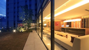 A modern hotel lobby with a reception desk, seating area, and glass walls. - Richmond Hotel Premier Asakusa International (Tokyo)