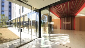 A modern hotel lobby with glass doors, a red interior, and a sign reading "Richmond Hotel". - Richmond Hotel Premier Asakusa International (Tokyo)