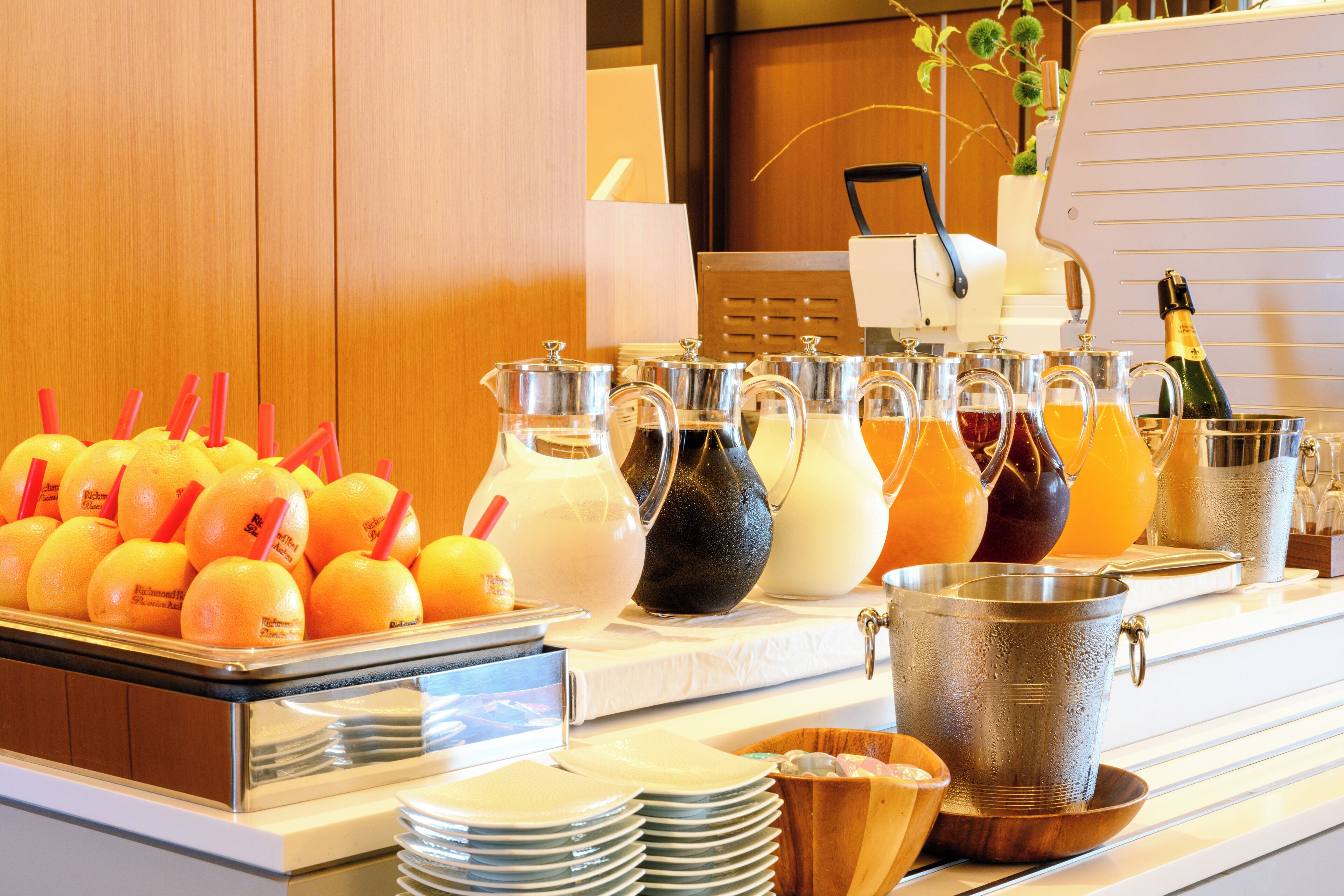 A buffet with various beverages and fruits.