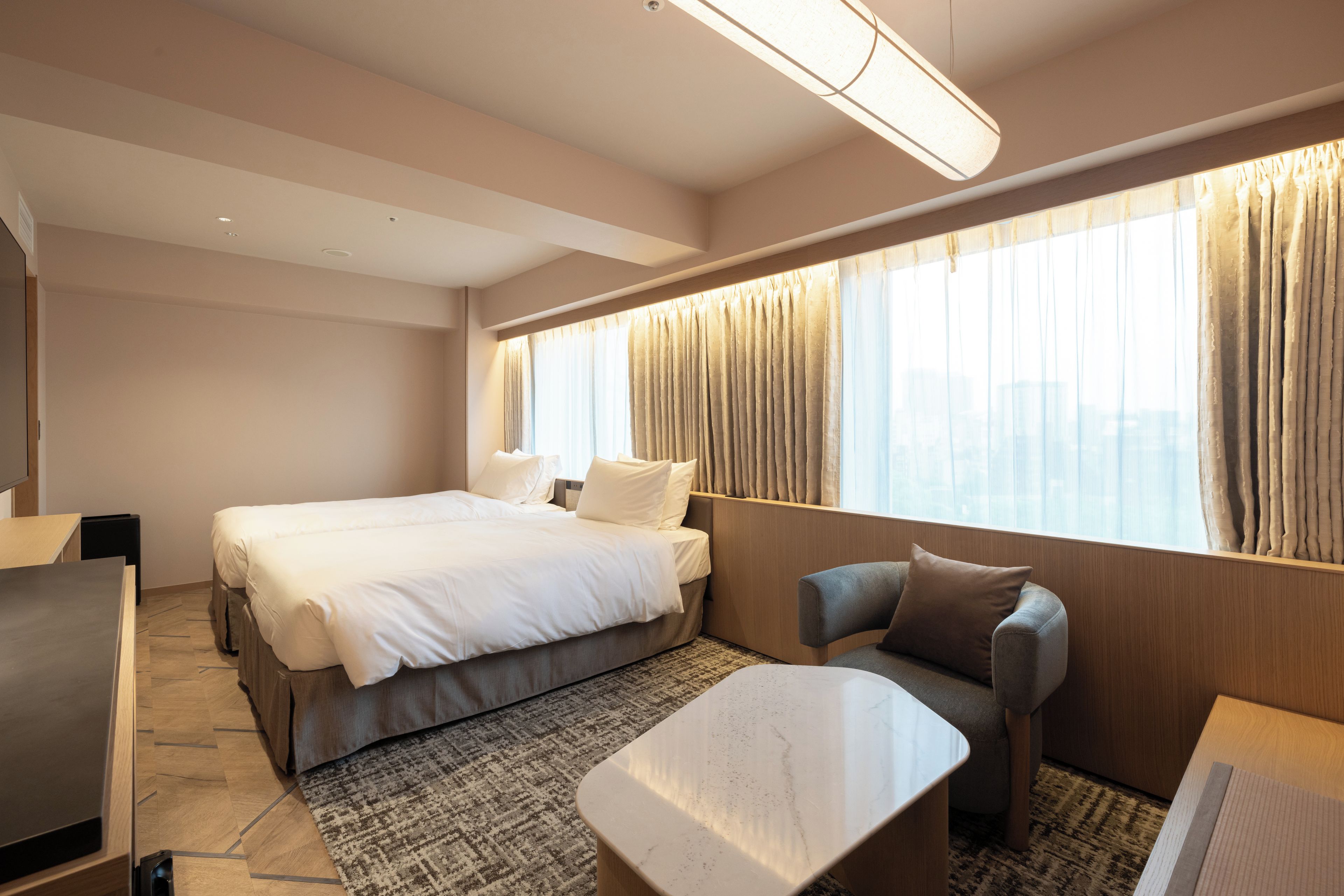 Une chambre d’hôtel avec un grand lit, un canapé, une petite table et un téléviseur.