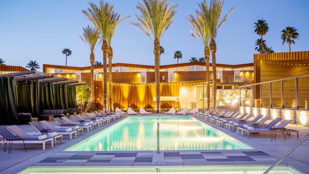 A swimming pool with lounge chairs and palm trees. - ARRIVE Palm Springs - Adults Only (Palm Springs)