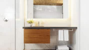 A modern bathroom with a wooden vanity, a mirror, and a shower.
