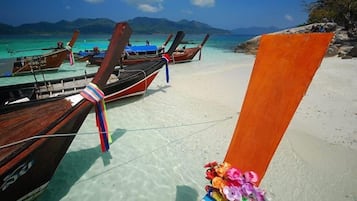 A beach with boats and a clear view of the sea.