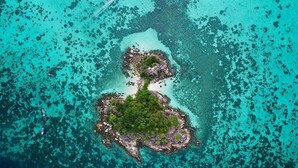 An aerial view of a small island with clear turquoise waters and lush green vegetation. - Family Song Bungalow (Koh Lipe)