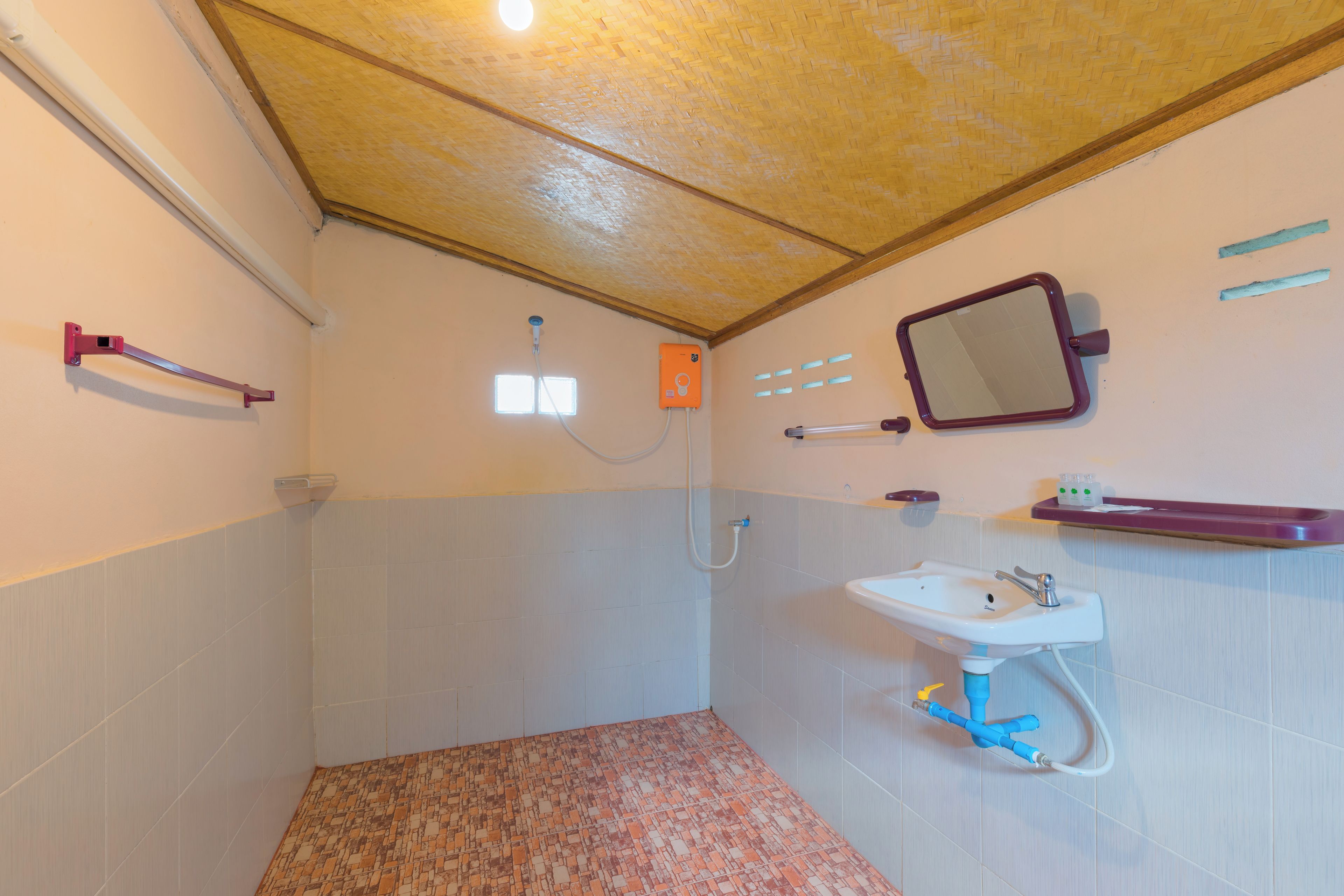 Un baño con ducha, lavabo, espejo y toallero.