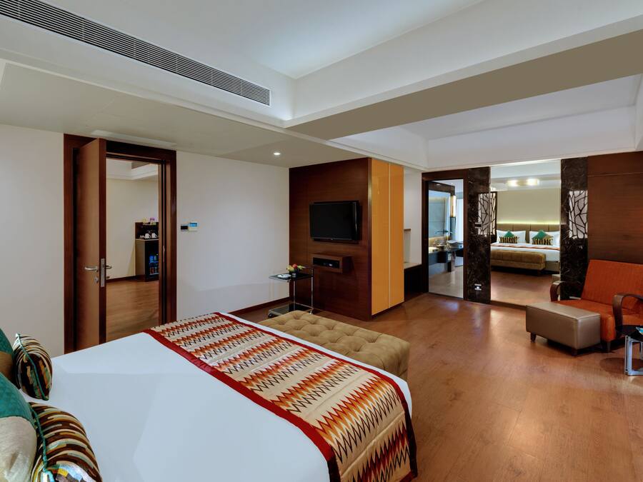Une chambre d’hôtel moderne équipée d’un grand lit, d’une télévision, d’un bureau et d’un coin salon.