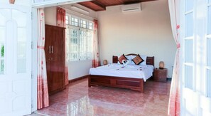 A bedroom with a wooden bed, a nightstand, a wardrobe, and a window with curtains. - Rice Village Homestay (Da Nang)