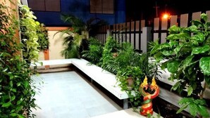 Un espace extérieur bien entretenu, agrémenté de diverses plantes et d’une statue décorative.