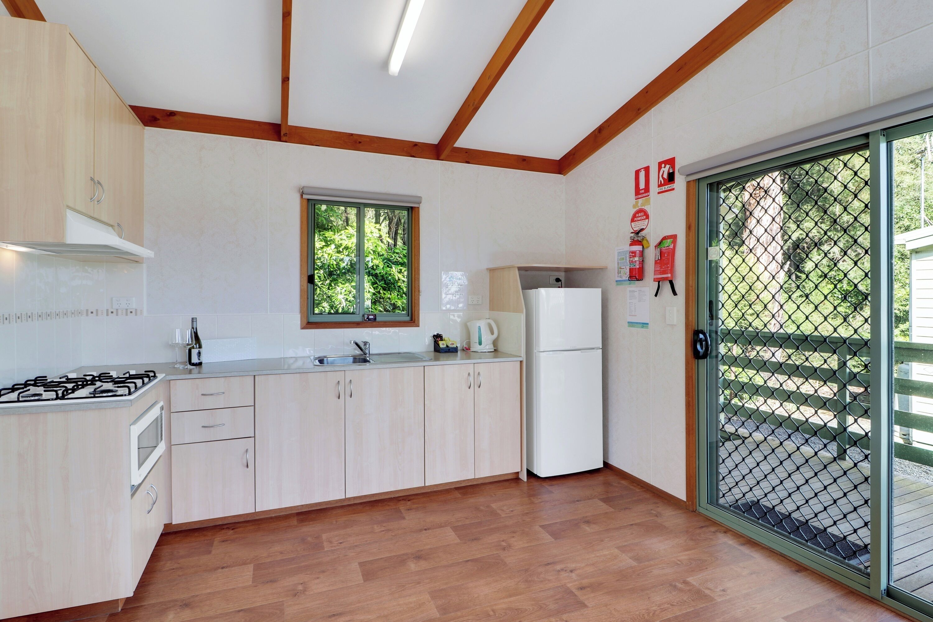 Una cocina moderna con armarios de madera, estufa a gas, microondas y refrigerador.