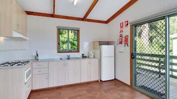 Una cocina moderna con armarios de madera, estufa a gas, microondas y refrigerador.