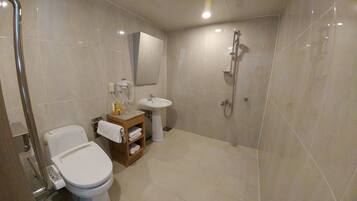 Un baño moderno con inodoro, lavabo y ducha.