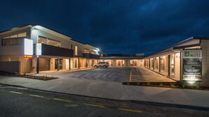 A modern motel with a parking lot and a car parked in front. - Pedlars Motel (Paeroa)