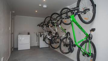 Una habitación con un aparcavesisletas que contiene varias bicicletas, una lavadora y una secadora.
