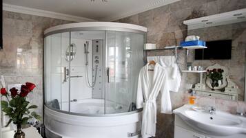 Ein modernes Badezimmer mit einer einteiligen Duschkabine, einer weißen Badewanne, einem Waschtisch und einem Spiegel.