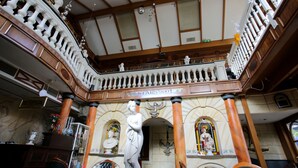 Un intérieur somptueux comprenant un hall d’accueil, des colonnes richement décorées et un balcon agrémenté de balustrades.