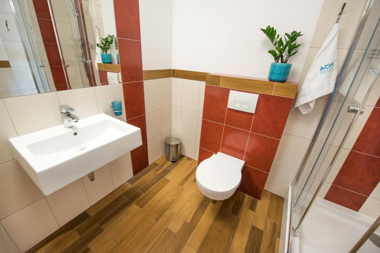 A bathroom with a sink, toilet, and shower area.