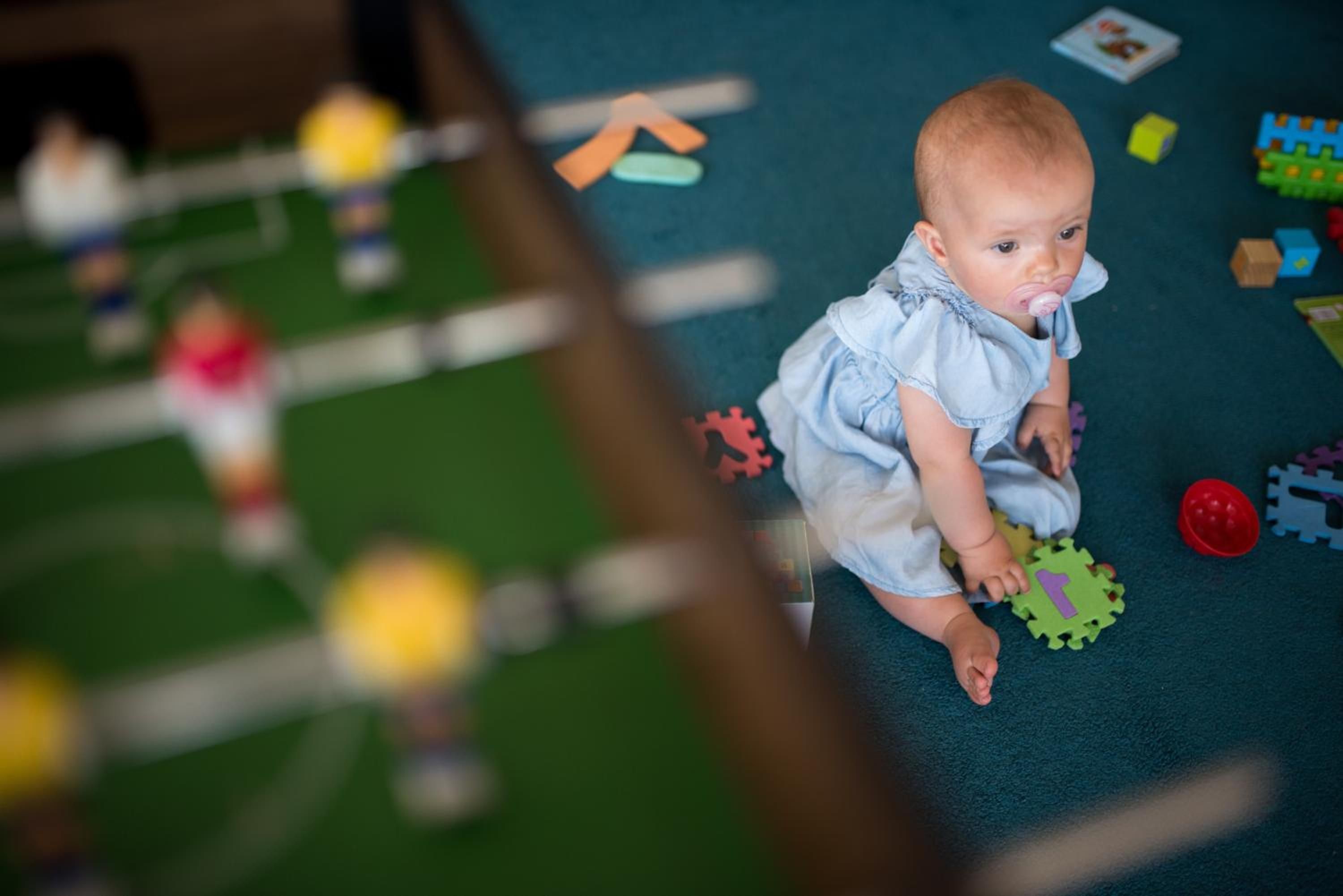 Un enfant joue avec des pièces de puzzle sur un tapis.