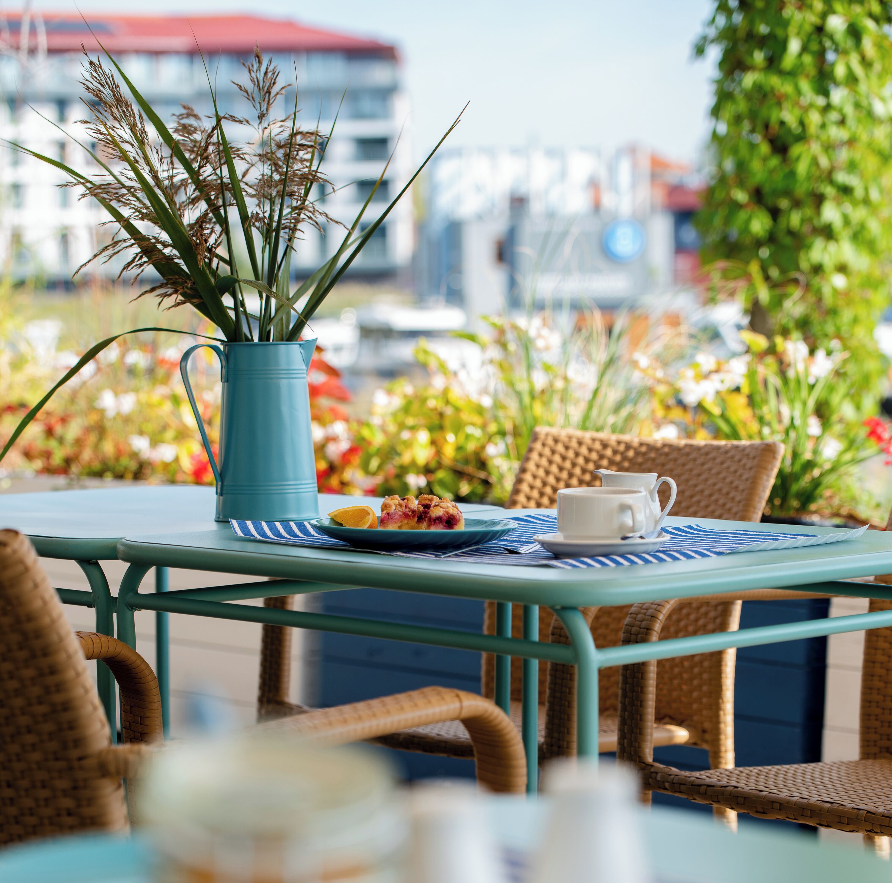 A table with a blue vase, a white cup, and a plate with food.