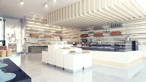 A modern bakery with a clean, minimalist design, featuring white cabinetry and a central display counter. - Grandia Hotel (Bandung)