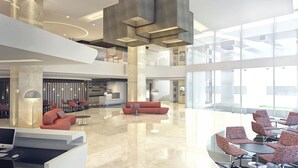 A spacious lobby with a high ceiling, modern furniture, and large windows. - Grandia Hotel (Bandung)