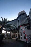 Un edificio moderno con fachada de vidrio curva y un letrero que dice "Grandia Chinese Food".