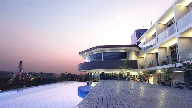 A modern building with a curved roof and a wooden deck. - Grandia Hotel (Bandung)