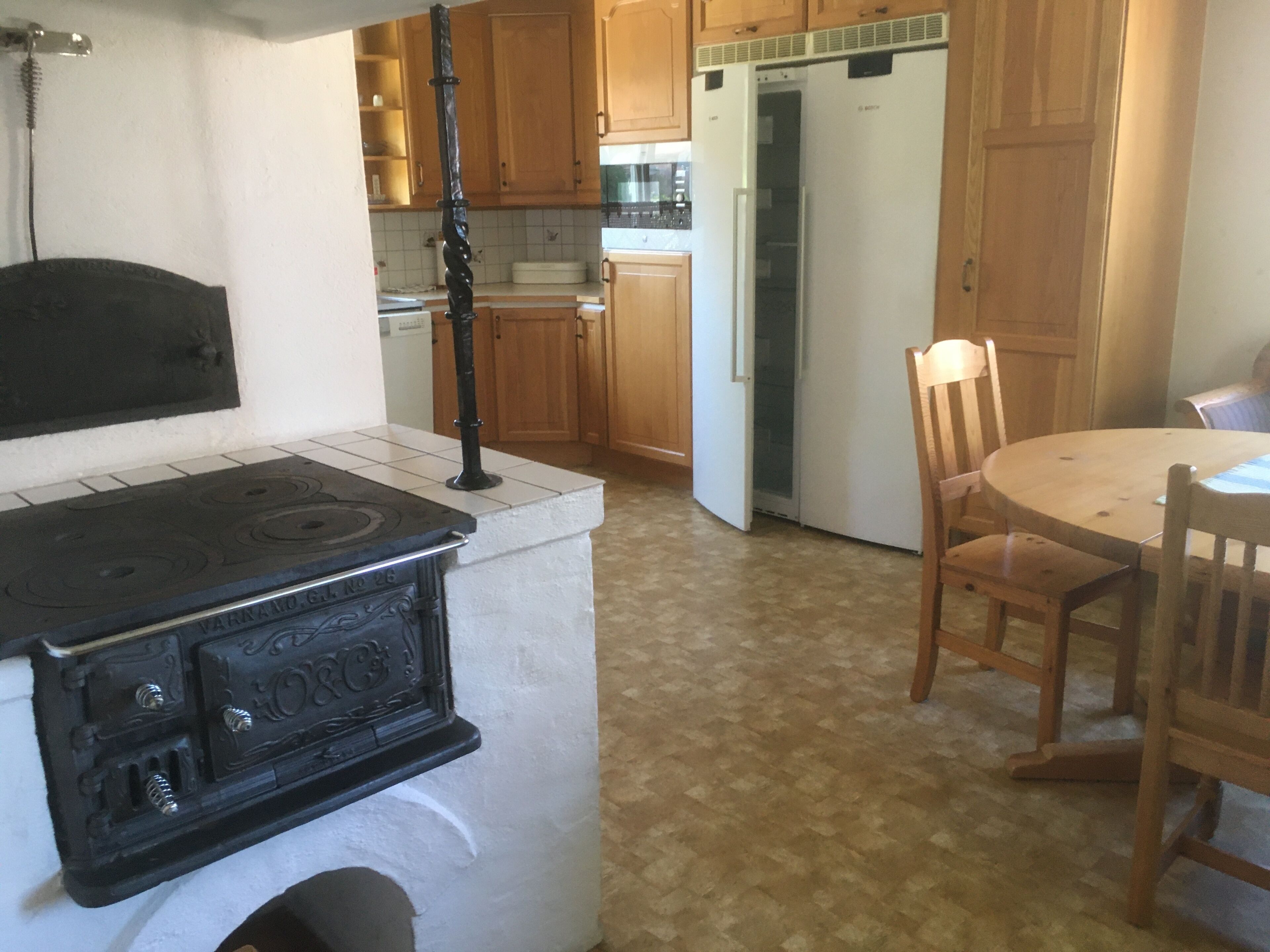 A kitchen with wooden cabinets, a stove, and a refrigerator.